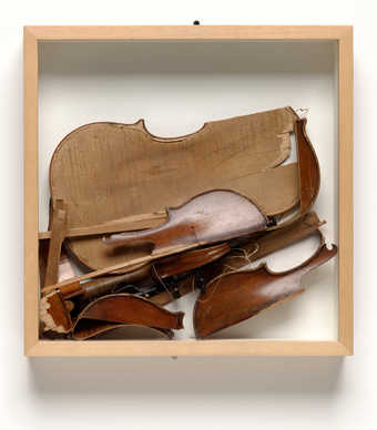 A wood box containing a smashed violin.