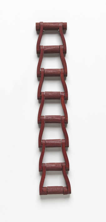 A carved wooden chain painted with an oxblood colored painted.