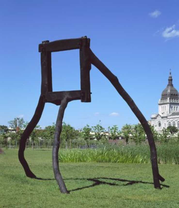 parts of white oak trees that have been cut and charred, stand in a tripod creating a square...