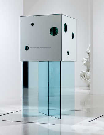 A mirror cube with round access holes cut to the interior exposing a mirror lined interior,...