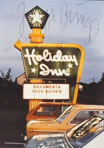 Photo by Staeck/Steidl; image is of a Holiday Inn sign with message board bearing the words...