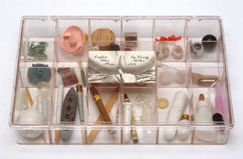 18 compartment clear plastic box with hinged lid, label on lid with title and label on inside of...