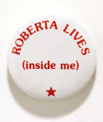 Metal button , white with red lettering that reads, "ROBERTA LIVES/ (inside me).