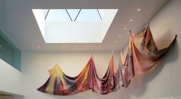 Brightly painted canvas mostly reds and yellows looks almost tie dyed.  When installed canvas in...