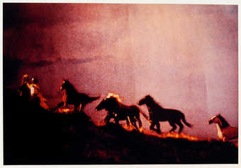 An image of Marlboro men on horseback, riding on a hilltop