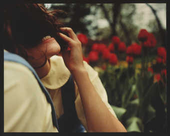 An image of a young woman with her hair in front her face showing her bared teeth