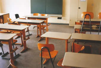 shot of a classroom with desks, chairs, and chalk board