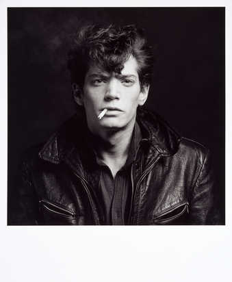 A black-and-white portrait of the artist with a cigarette in his mouth, wearing a leather jacket.