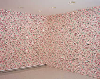 Pink wallpaper with a repeating design of sylized eyes.