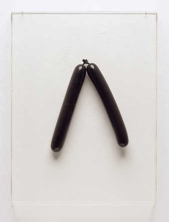 Two black balloons inflated and installed to the artist's specifications, behind a...