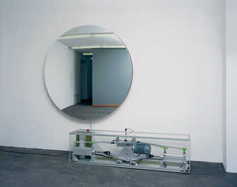 A pump mechanism inflates and deflates a circular piece of stretched mirrored mylar, making the...