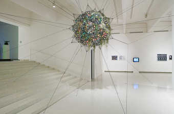 A series of PVC balloons in 2 sizes suspended within a matrix of black webbing, Partially covered...